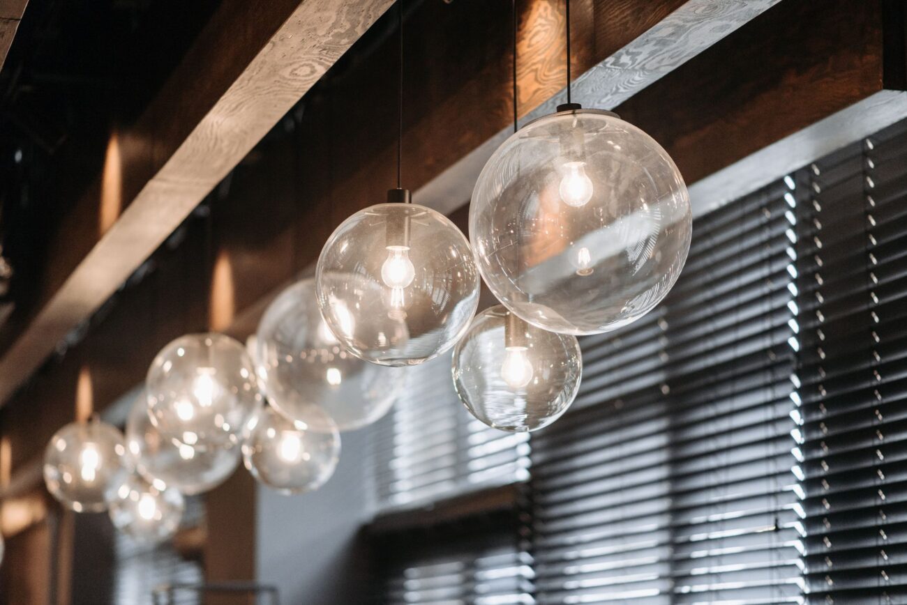 Stylish glass ball light fixtures hanging indoors with soft lighting and wooden accents. – oversized smart sphere lights for patios